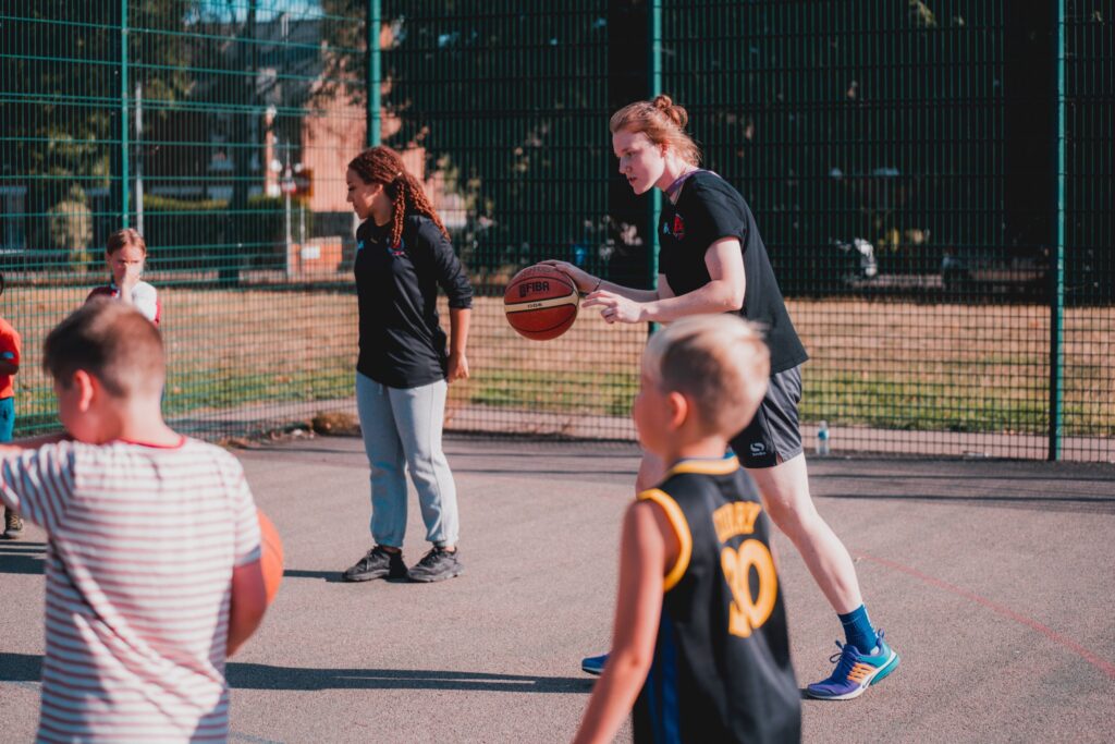 Essex Rebels Player dribbling and instructing children