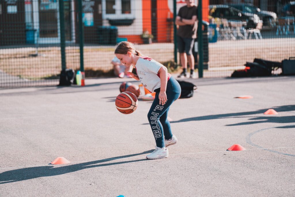 young girl playing basketball at the park